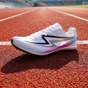 A white athletic track shoe with black and pink accents resting on a red running track.